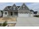 Charming two-story home with gray shake siding, a three-car garage, and unfinished front yard at 921 Lily Claire Ln, Fuquay Varina, NC 27526