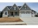 Beautiful craftsman home featuring a gray shingle exterior, white painted brick and a two-car garage at 921 Lily Claire Ln, Fuquay Varina, NC 27526