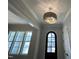 Foyer featuring a stylish light fixture, arched front door, and large window at 921 Lily Claire Ln, Fuquay Varina, NC 27526