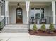 Inviting front porch with stone steps, seating, and elegant wooden door, perfect for relaxing at 921 Lily Claire Ln, Fuquay Varina, NC 27526