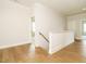 Upstairs hallway with wood flooring and white trim, leading to bedrooms and additional living spaces at 921 Lily Claire Ln, Fuquay Varina, NC 27526