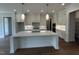 Spacious kitchen with white cabinets, a large center island, and modern stainless-steel appliances at 921 Lily Claire Ln, Fuquay Varina, NC 27526