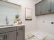 The laundry room features stylish gray cabinetry, a utility sink, and a durable tile floor at 921 Lily Claire Ln, Fuquay Varina, NC 27526