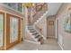 Elegant foyer with tile flooring, a chandelier, a staircase with iron railings, and a decorative front door at 9332 Leslieshire Dr, Raleigh, NC 27615