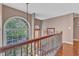 Bright hallway with hardwood floors, arched windows overlooking greenery, and a decorative chandelier at 9332 Leslieshire Dr, Raleigh, NC 27615