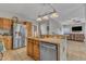 Cozy kitchen with stainless steel appliances, tile backsplash, and a unique island lighting fixture at 9332 Leslieshire Dr, Raleigh, NC 27615