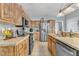 Well-lit kitchen with stainless steel appliances, wood cabinets, and tile backsplash at 9332 Leslieshire Dr, Raleigh, NC 27615