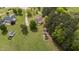 Aerial view shows the home, spacious yard, barn, and the partly-enclosed area for animals on a sunny day at 10 Gray Bass Ct, Zebulon, NC 27597