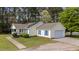 Side view of home with solar panels, and attached garage, complemented by blue shutters and a well-maintained lawn at 10 Gray Bass Ct, Zebulon, NC 27597