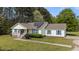 Inviting single-story home with a charming front porch, solar panels, blue shutters, and a well-maintained front lawn at 10 Gray Bass Ct, Zebulon, NC 27597