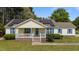 Charming single-story home features a covered front porch, bright blue shutters, solar panels, and a well-manicured lawn at 10 Gray Bass Ct, Zebulon, NC 27597