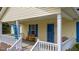Charming front porch with a seating bench, white railing, and a bright blue front door and shutters at 10 Gray Bass Ct, Zebulon, NC 27597