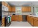 An efficient kitchen features wood cabinets, neutral countertops, modern backsplash, and sleek appliances at 10 Gray Bass Ct, Zebulon, NC 27597