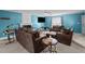A living room with blue walls features a fireplace, large windows, neutral carpet, and ample seating at 10 Gray Bass Ct, Zebulon, NC 27597