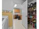 View of kitchen and walk-in pantry with wire shelves stocked with food, beverages, and a view of a kitchen with wood cabinets at 10 Gray Bass Ct, Zebulon, NC 27597