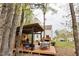 The spacious backyard features an outdoor kitchen, seating area, and a two-story home with a wooden deck at 10 Shearin Ln, Youngsville, NC 27596