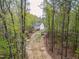 A home with a spacious backyard, featuring a deck and surrounded by a dense forest landscape at 10 Shearin Ln, Youngsville, NC 27596