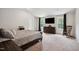 Bright main bedroom with large windows, a mounted TV, and a comfortable rocking chair at 10 Shearin Ln, Youngsville, NC 27596