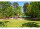 Vibrant playground area with colorful equipment surrounded by lush greenery and shady trees at 10 Shearin Ln, Youngsville, NC 27596
