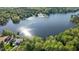 Aerial view showcasing the lake and lush surrounding wooded area at 104 Chuckwagon Dr, Louisburg, NC 27549