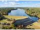 Scenic aerial view of lake, dam, and surrounding wooded areas at 104 Chuckwagon Dr, Louisburg, NC 27549