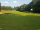 View of the lush green golf course with a white flag marking the hole at 104 Chuckwagon Dr, Louisburg, NC 27549