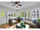 Relaxing sunroom with plenty of natural light, a ceiling fan, and views of the surrounding trees and lake at 104 Chuckwagon Dr, Louisburg, NC 27549
