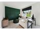 Cozy living room featuring a green accent wall, comfortable seating, and a view of the outdoors at 10516 Pleasant Branch Dr # 34, Raleigh, NC 27614