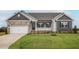 Charming single-story home featuring a stone facade, a well-manicured lawn, and an attached two-car garage at 11470 International Dr, Middlesex, NC 27557