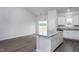 Kitchen island with sleek granite countertop, modern white cabinetry, and convenient under-counter storage at 11470 International Dr, Middlesex, NC 27557