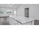 Kitchen island featuring granite countertop and white cabinets, complemented by modern kitchen finishes at 11470 International Dr, Middlesex, NC 27557
