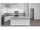 Modern kitchen with stainless steel appliances, white cabinetry, and island featuring stylish granite countertops at 11470 International Dr, Middlesex, NC 27557