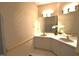 Bathroom with double sinks, a large mirror, and patterned wallpaper at 12124 Warwickshire Park, Raleigh, NC 27613