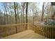 View of the new wooden deck overlooking trees and a flowering bush at 12124 Warwickshire Park, Raleigh, NC 27613