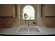 Close-up of a white double sink with an arched window view at 12124 Warwickshire Park, Raleigh, NC 27613