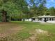 A large front yard with a white house, green lawn, and mature trees at 1243 Nc 231, Wendell, NC 27591