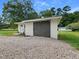 Garage with an overhang and a neutral door surrounded by gravel at 1243 Nc 231, Wendell, NC 27591