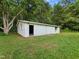 View of a small outbuilding with white siding and a sliding door at 1243 Nc 231, Wendell, NC 27591
