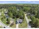 Aerial view showcasing a blue house with a well-manicured lawn in a wooded suburban community at 129 Camille Cir, Youngsville, NC 27596
