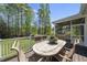Spacious outdoor deck featuring a table with seating and a view of the screened porch and lush backyard at 129 Camille Cir, Youngsville, NC 27596