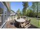 Outdoor deck featuring a table with seating for four that overlooks the well-maintained lawn and surrounding trees at 129 Camille Cir, Youngsville, NC 27596
