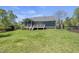 Exterior back of home with a screened-in porch, a deck, lush lawn and mature trees offering a private outdoor space at 129 Camille Cir, Youngsville, NC 27596