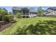 Home's back exterior with manicured lawn, a deck and screened in porch for enjoying the outdoors at 129 Camille Cir, Youngsville, NC 27596