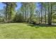 Well-maintained backyard lawn with mature trees and landscaping that creates a private and serene outdoor space at 129 Camille Cir, Youngsville, NC 27596