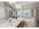 The bright bathroom has a double vanity, soaking tub, and glass-enclosed shower at 129 Camille Cir, Youngsville, NC 27596