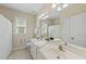 Well-lit bathroom features a double vanity, large mirror, and decorative accents at 129 Camille Cir, Youngsville, NC 27596