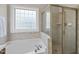 Relaxing bathroom featuring a soaking tub and a separate glass-enclosed shower at 129 Camille Cir, Youngsville, NC 27596
