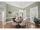 The dining room has hardwood floors, a chandelier, and multiple windows with plantation shutters at 129 Camille Cir, Youngsville, NC 27596