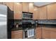 The kitchen features wooden cabinets, stainless steel appliances, and a dark countertop at 129 Camille Cir, Youngsville, NC 27596