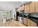 Modern kitchen with stainless steel appliances, granite countertops, and adjacent dining area with deck access at 129 Camille Cir, Youngsville, NC 27596